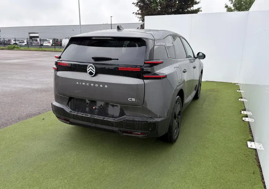 Vue 3/4 arrière droite d'une Citroën C5 Aircross 2026 gris platinium avec toit noir et feux arrière LED distinctifs.