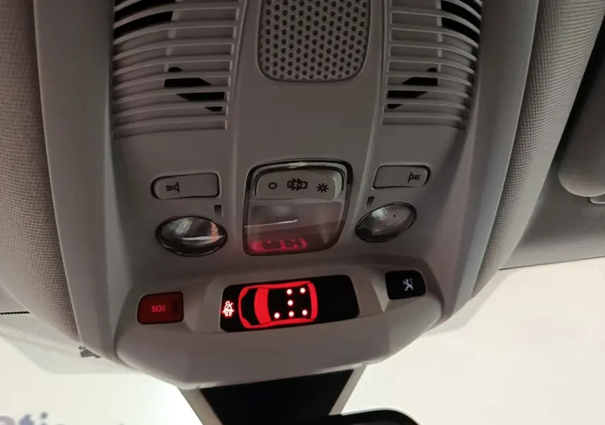 Vue en gros plan du plafonnier intérieur du Peugeot 5008 noir, avec boutons d’éclairage et affichage de porte ouverte rouge.