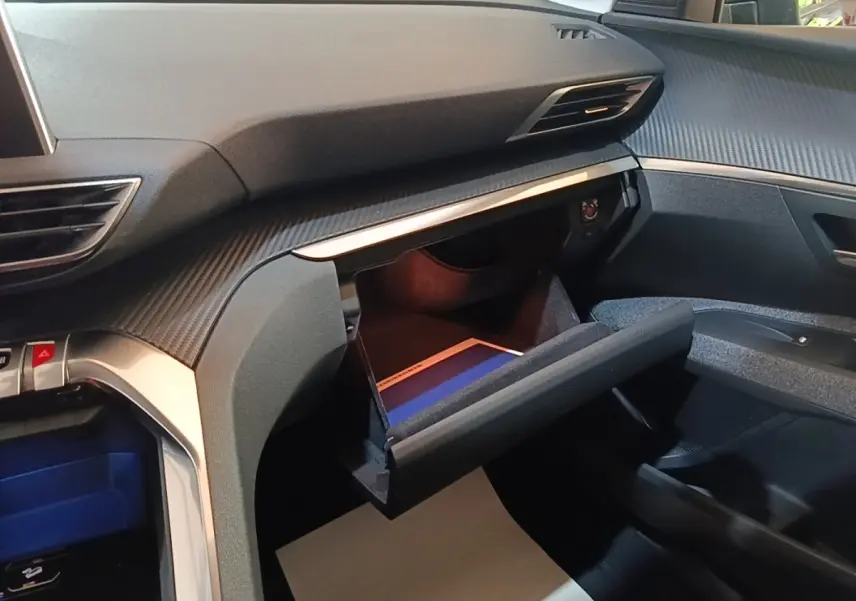 Vue intérieure côté passager du Peugeot 5008 2018, boîte à gants ouverte avec éclairage intérieur visible.