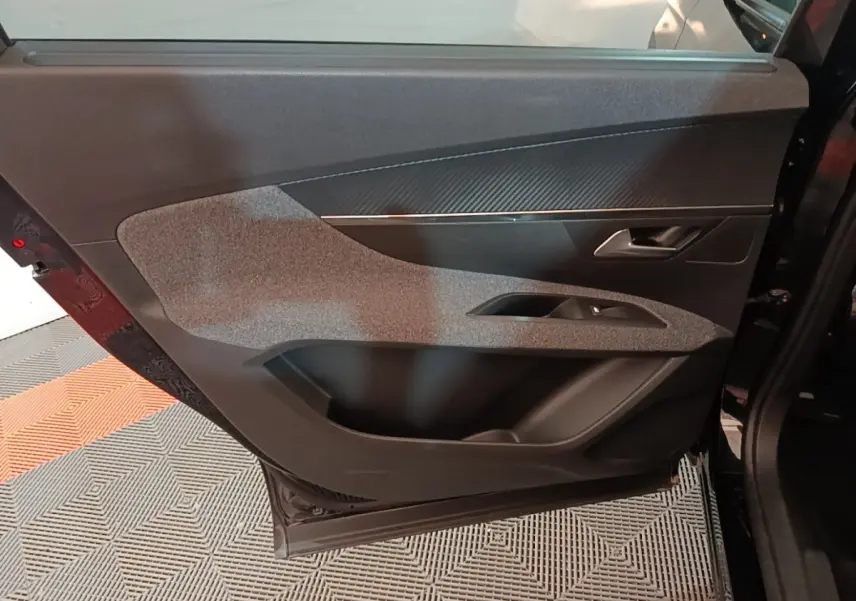 Vue intérieure de la porte arrière droite noire du Peugeot 5008 avec garniture grise et poignée argentée.