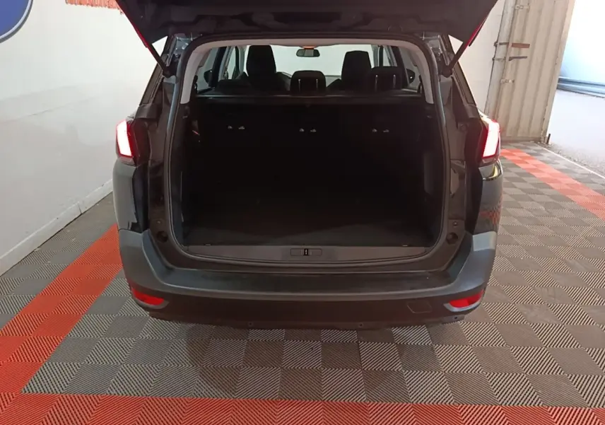 Vue arrière d'un Peugeot 5008 noir 2018 avec coffre ouvert et feux arrière allumés dans un garage.