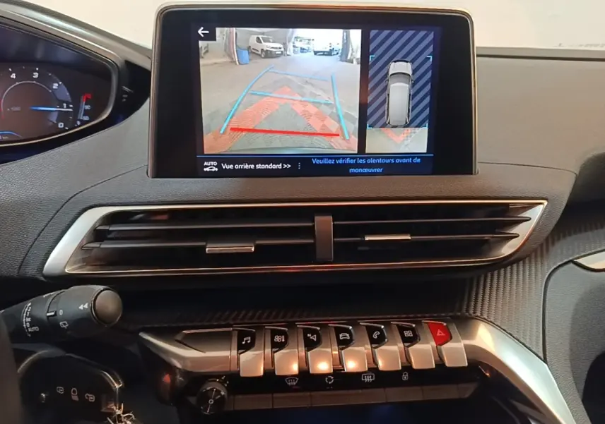 Vue intérieure du tableau de bord du Peugeot 5008 noir, écran tactile affichant la caméra de recul avec guidage.