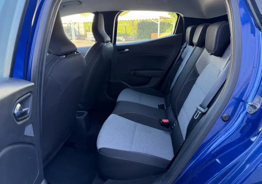 Vue intérieure côté droit sur la banquette arrière gris clair et noir d'une Renault Clio bleu 2024 avec porte ouverte.