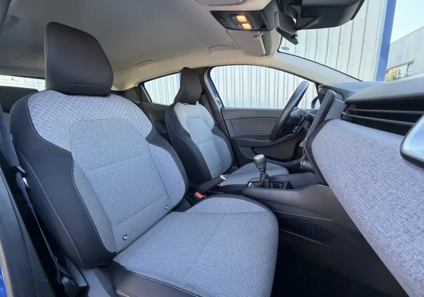 Vue intérieure côté droit de la Renault Clio Evolution TCe 90 2024, sièges tissu gris et tableau de bord assorti.