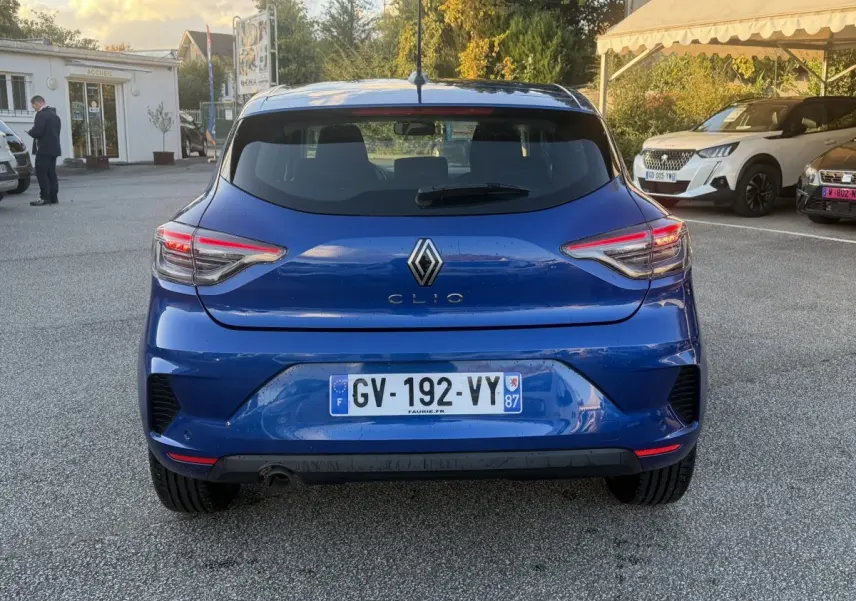 Vue arrière d'une Renault Clio Evolution TCe 90 bleu 2024 avec feux LED et plaque d'immatriculation française.