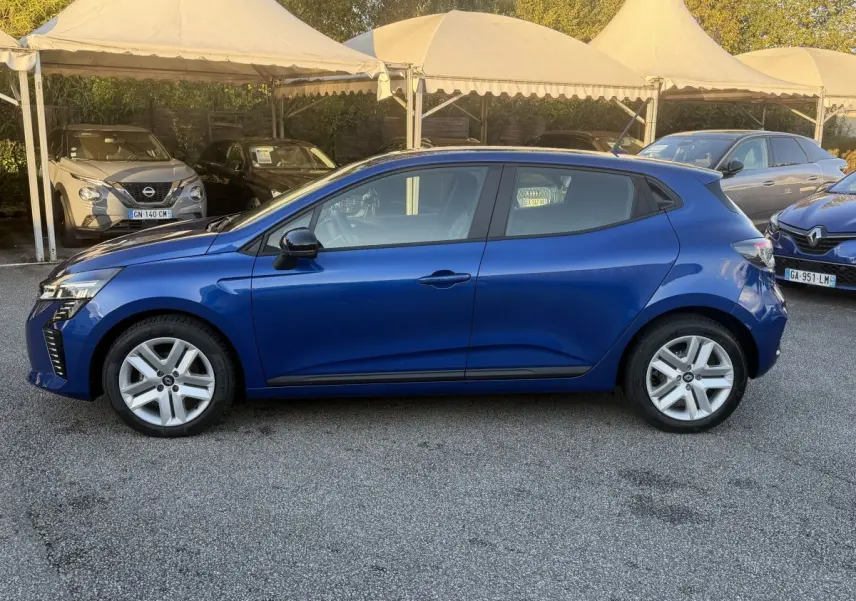 Profil droit d'une Renault Clio Evolution TCe 90 bleu 2024, avec jantes alliage et rétroviseurs noirs, stationnée en extérieur.