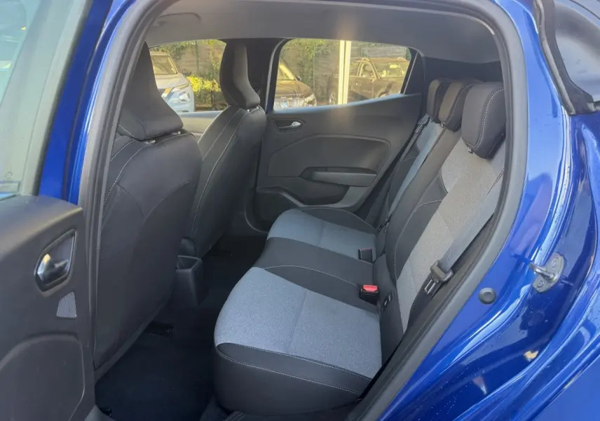Vue intérieure arrière droite de la Renault Clio Evolution TCe 90 2024 bleu, montrant la banquette 3 places bicolore.