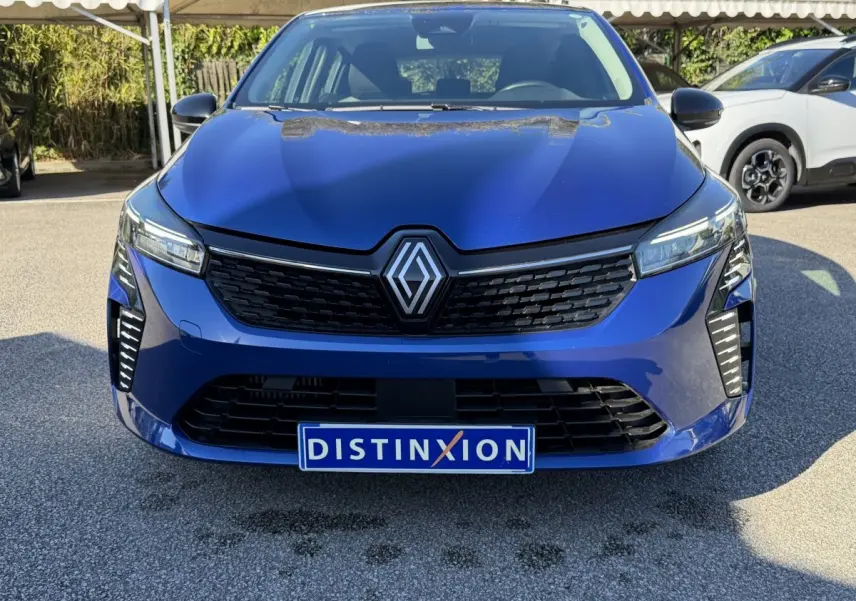 Vue frontale d'une Renault Clio Evolution TCe 90 bleu avec calandre noire et feux LED distinctifs.
