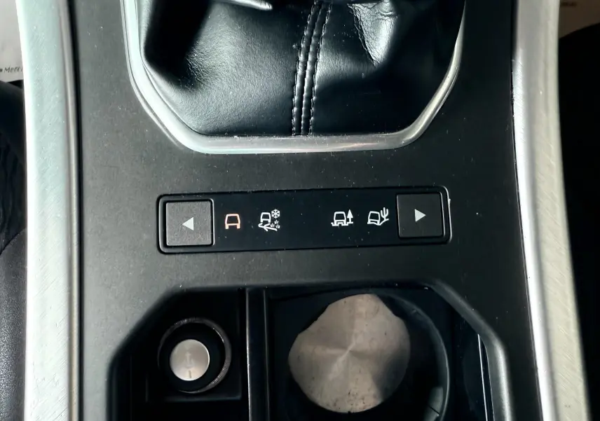 Gros plan sur la console centrale noire du Range Rover Evoque 2017, montrant le levier de vitesses manuel et les commandes de modes de conduite.