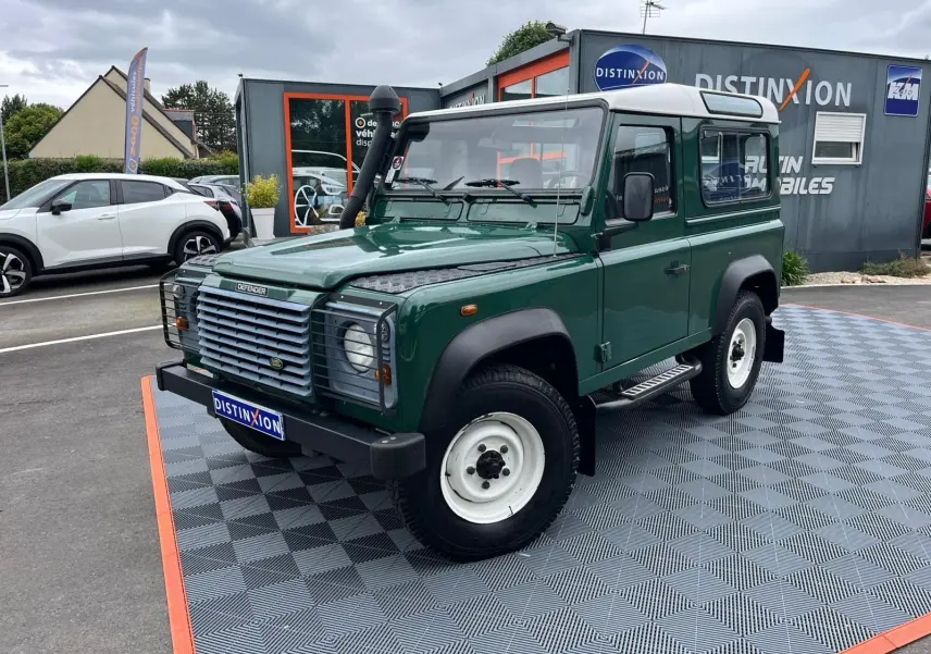 Land Rover Defender 90 vert vue 3/4 avant droit avec snorkel, marchepieds et toit blanc Hard Top.