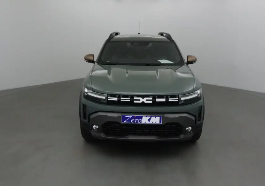 Vue frontale du Dacia Duster 2025 kaki lichen avec calandre distinctive et phares LED fins allumés.