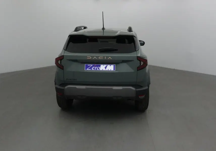 Vue arrière d'un Dacia Duster 2025 kaki lichen avec logo Dacia doré et plaque Zero KM visible.