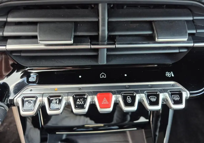 Vue rapprochée des commandes centrales du tableau de bord noir du Peugeot 2008 Hybrid 145 e-DCS6 GT 2024.