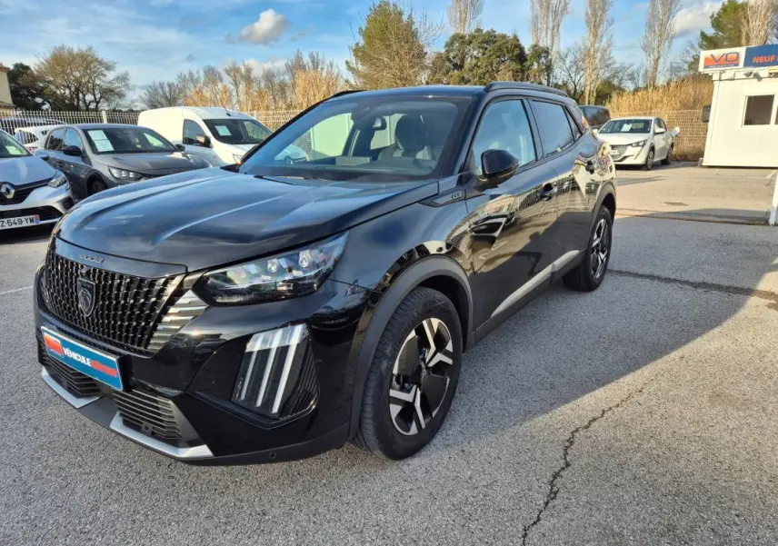 Peugeot 2008 Hybrid 145 e-DCS6 GT noir en 3/4 avant droit avec barres de toit et jantes alliage 18 pouces.