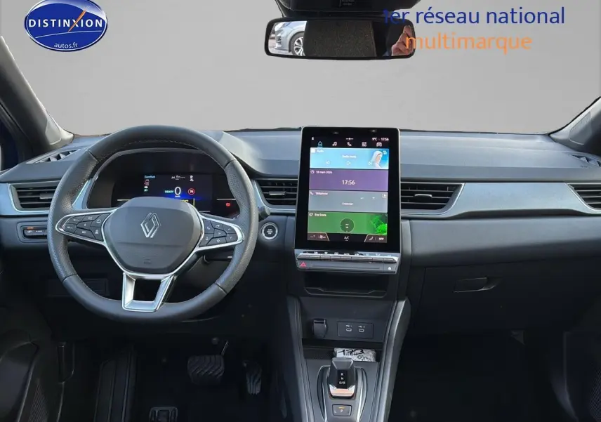 Vue intérieure frontale du tableau de bord du Renault Captur bleu iron, avec écran tactile vertical et volant multifonction.