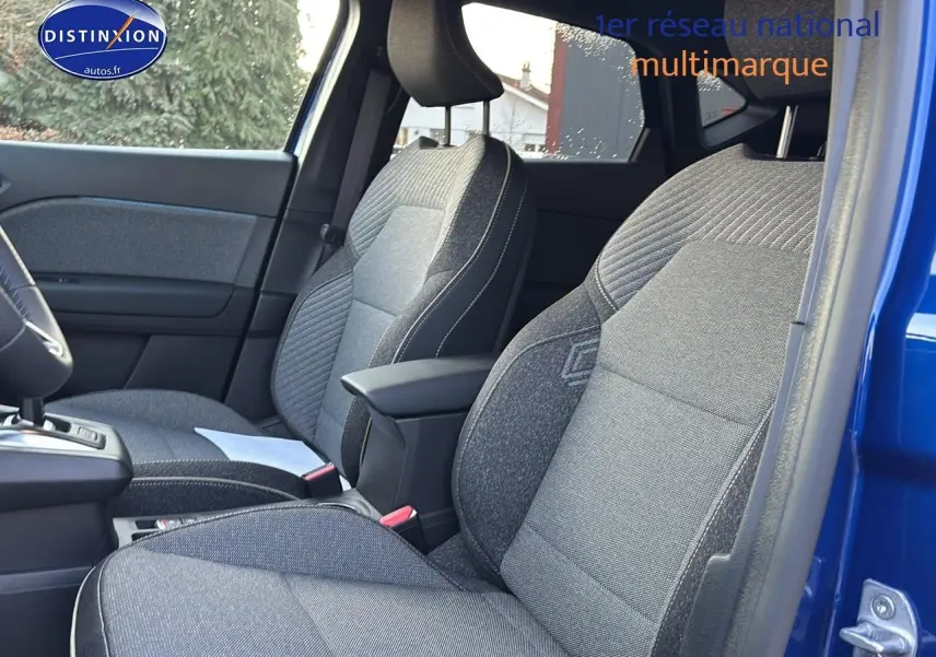 Vue intérieure côté droit montrant les sièges avant gris et l'accoudoir central du Renault Captur bleu iron 2026.