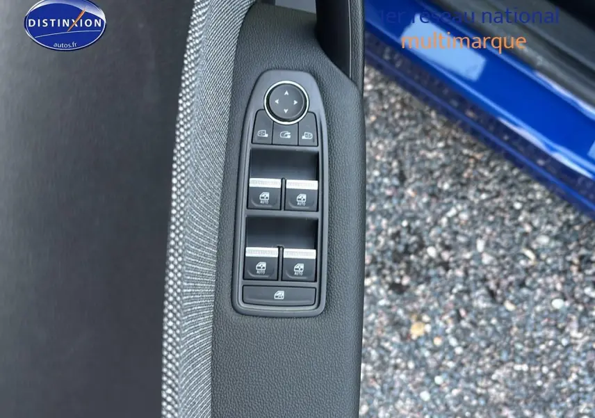 Détail des commandes des vitres électriques sur la porte avant gauche d'un Renault Captur bleu iron t/noir.