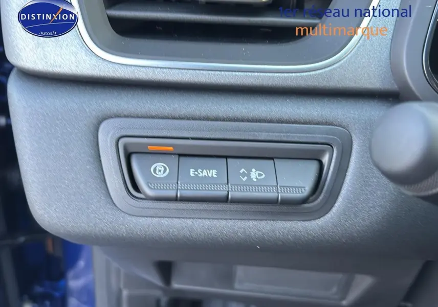 Gros plan sur les commandes E-SAVE et réglage des phares du tableau de bord du Renault Captur bleu iron.