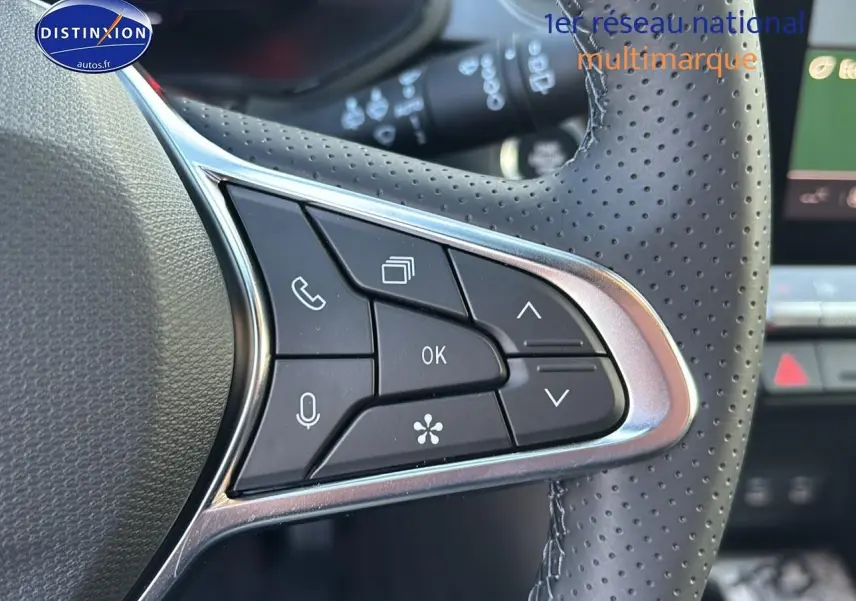 Gros plan sur les commandes multifonctions du volant en cuir perforé du Renault Captur bleu iron t/noir.