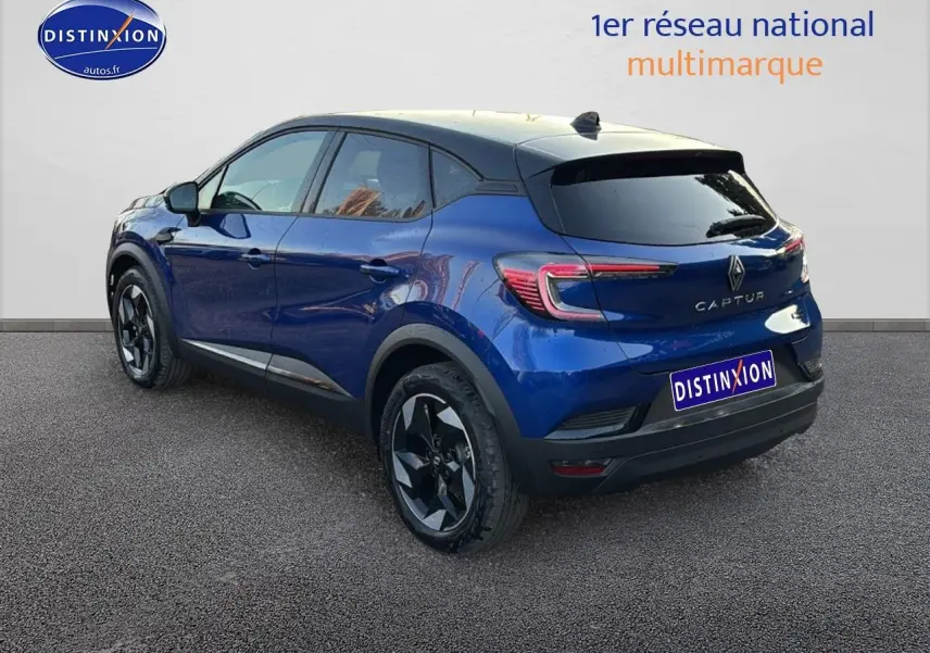Vue 3/4 arrière droite du Renault Captur bleu iron avec toit noir et jantes alu noires.