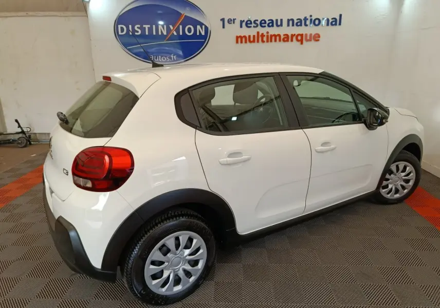 Vue 3/4 arrière droite d'une Citroën C3 blanche 2020 avec jantes acier et protections noires sur les passages de roues.