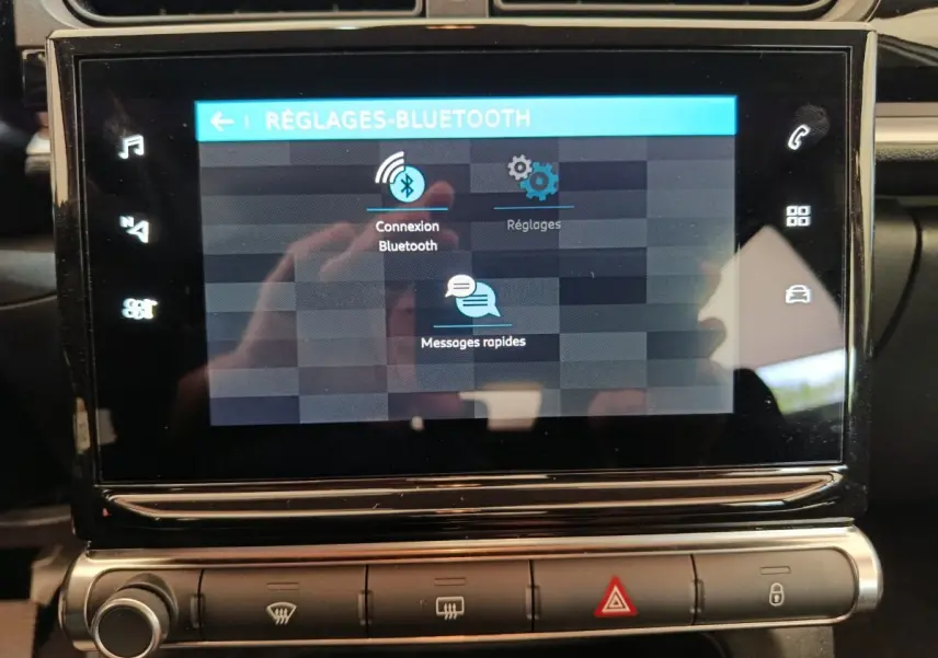 Écran tactile central de la Citroën C3 blanche, affichant les réglages Bluetooth en gros plan intérieur.