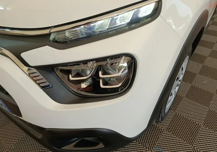 Gros plan sur le phare avant droit blanc de la Citroën C3 2020 avec détails LED et partie de la roue visible.