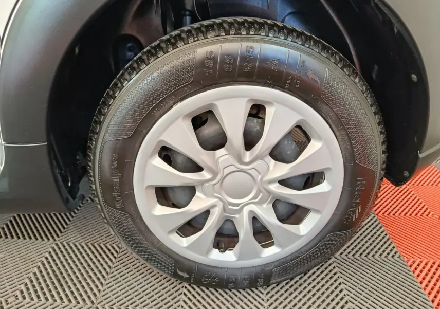 Gros plan sur la roue avant droite d'une Citroën C3 blanche, mettant en valeur la jante en plastique gris clair.