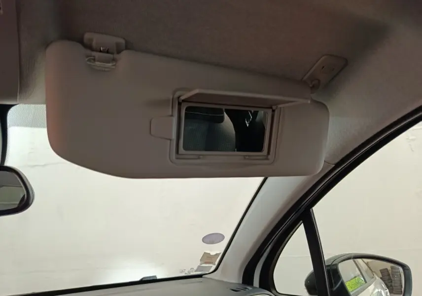 Détail intérieur montrant le pare-soleil côté conducteur avec miroir de courtoisie ouvert sur Citroën C3 blanche.
