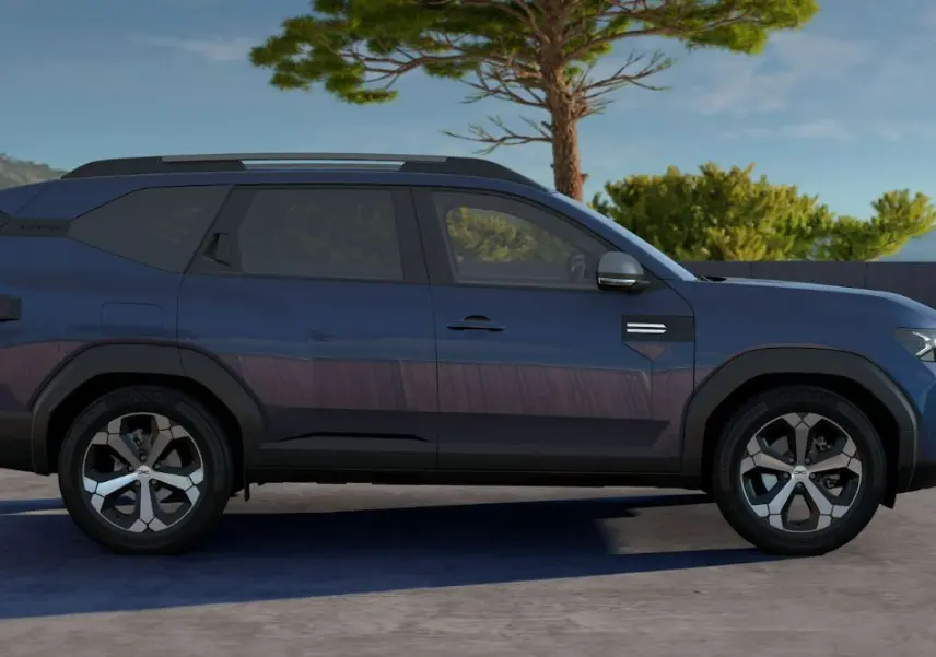 Profil droit du SUV Dacia Bigster bleu indigo 2026 avec jantes bi-ton et lignes anguleuses marquées.