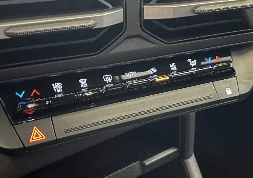 Gros plan sur la console centrale de la Dacia Bigster 2026, montrant les commandes tactiles de climatisation et le bouton de verrouillage.