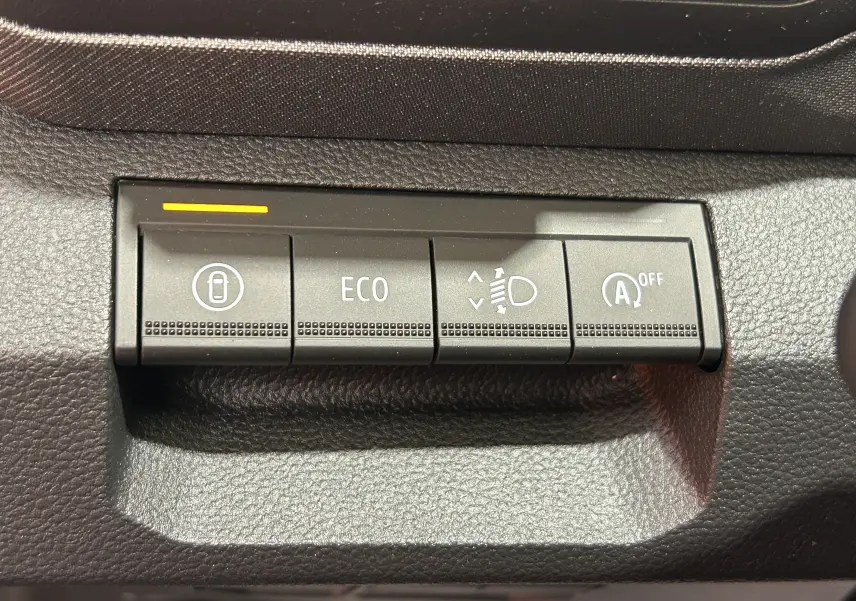 Boutons de commande intérieurs du Dacia Bigster 2026, vue rapprochée sur les fonctions ECO, réglage phares et arrêt auto start-stop.