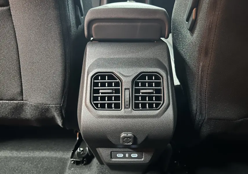 Vue rapprochée des aérateurs arrière et ports USB entre les sièges noirs du Dacia Bigster 2026.