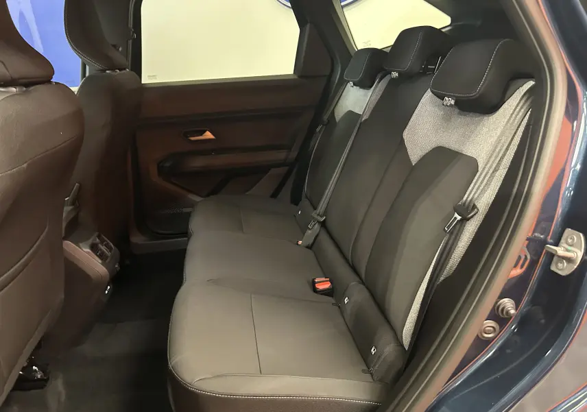 Vue intérieure côté droit des sièges arrière en tissu gris et noir du Dacia Bigster Bleu Indigo 2026 avec porte ouverte.