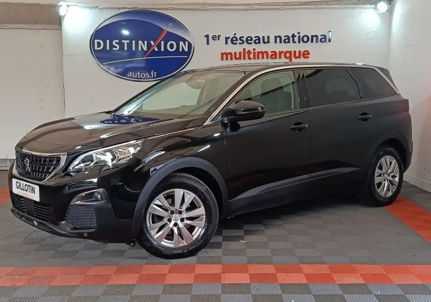 Peugeot 5008 noir en 3/4 avant droit, SUV familial avec jantes alliage et calandre distinctive Peugeot.