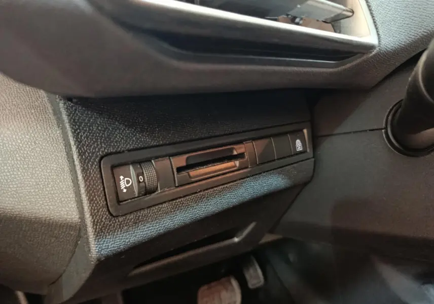 Détail du tableau de bord côté conducteur du Peugeot 5008 noir, avec commande réglage hauteur phares et verrouillage centralisé.