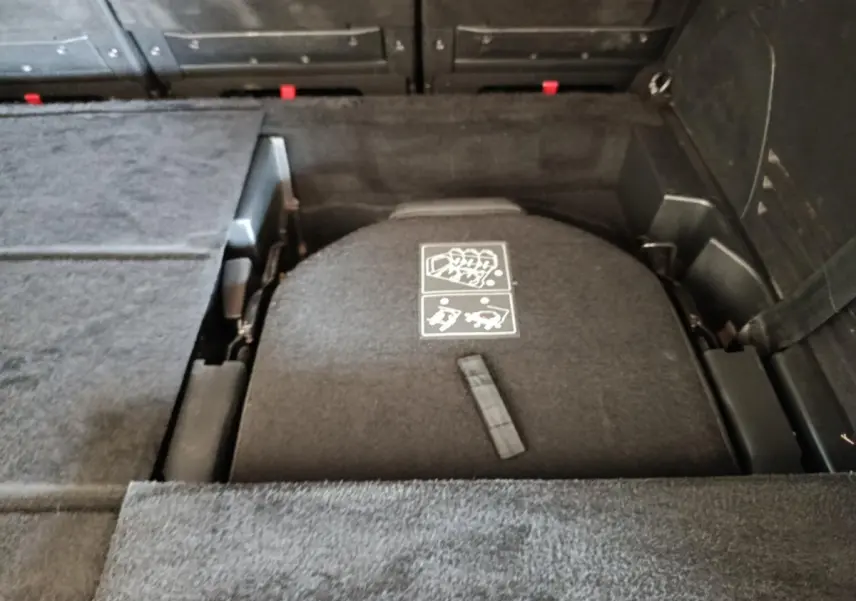Vue rapprochée du coffre du Peugeot 5008 noir, montrant le plancher plat avec sièges arrière rabattus.