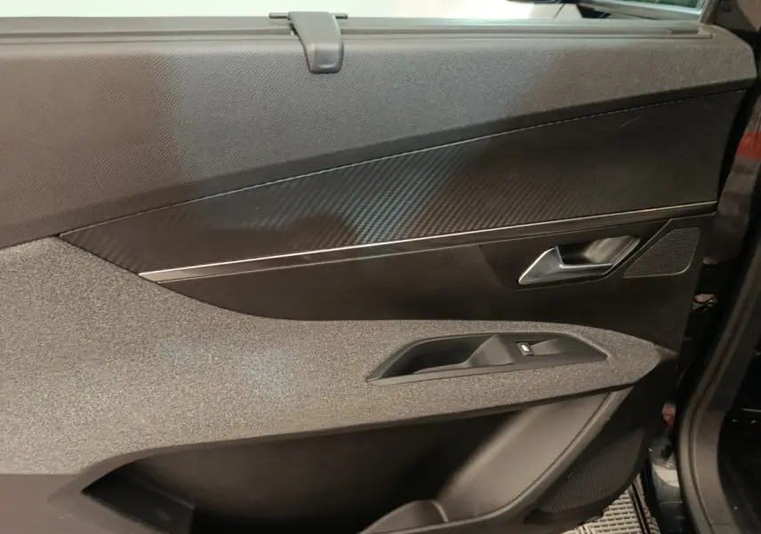Détail de la porte avant gauche noire du Peugeot 5008 2020 avec insert effet carbone et commande de vitre.