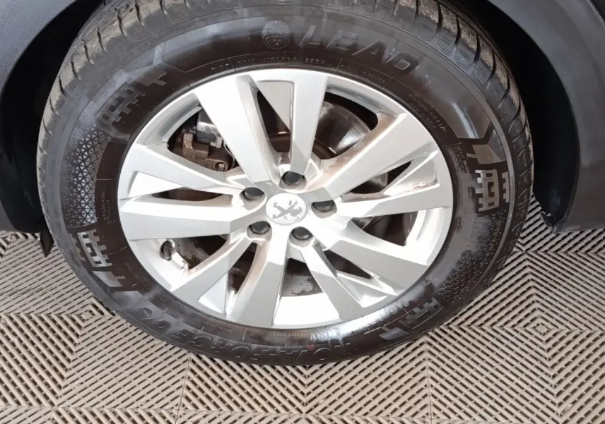 Gros plan sur la jante argentée et le pneu noir d'un Peugeot 5008 2020, avec logo lion au centre.