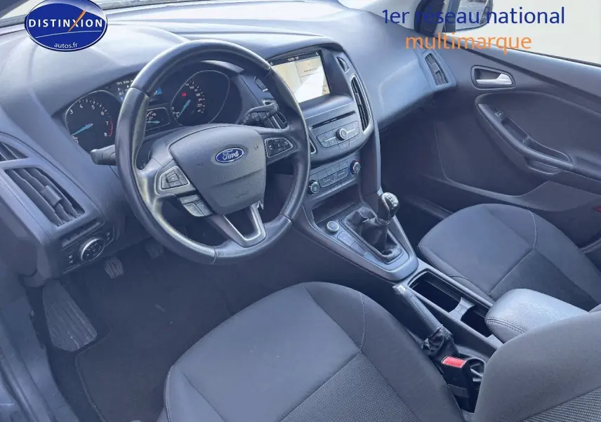 Intérieur de la Ford Focus SW 2018 vu côté conducteur, tableau de bord noir avec volant multifonction et boîte manuelle.