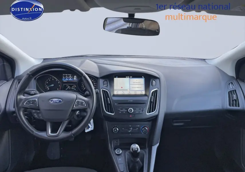 Vue intérieure frontale de la Ford Focus SW 2018, tableau de bord noir avec écran tactile et levier de vitesse manuel.