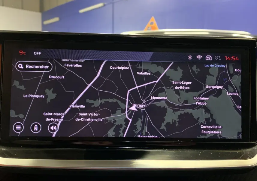 Écran de navigation GPS allumé dans le tableau de bord d'une Peugeot 2008 gris 2023, affichant une carte routière détaillée.