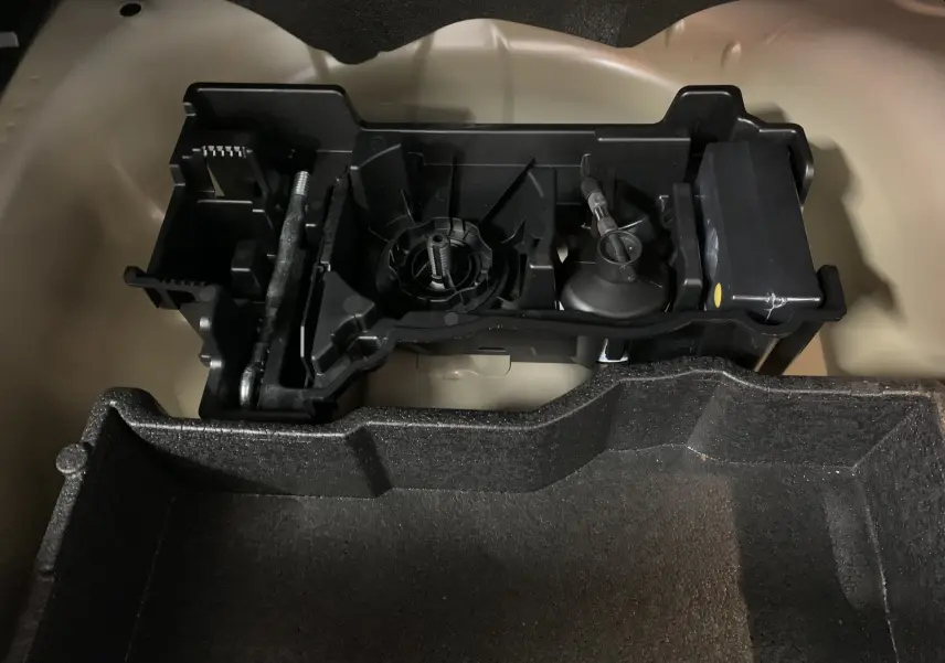 Gros plan sur le rangement d'outils dans le coffre du Peugeot 2008 gris BlueHDi 130 EAT8 GT 2023.