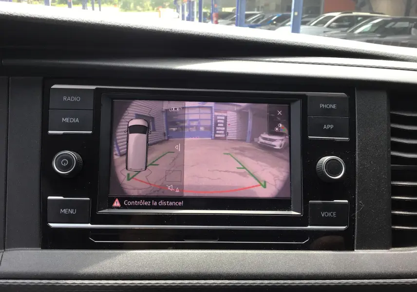 Écran central du Volkswagen Transporter 6.1 blanc montrant la caméra de recul avec guidage de trajectoire en intérieur véhicule.