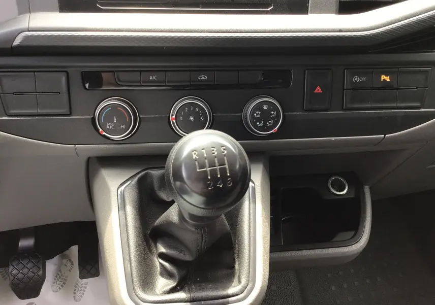 Gros plan sur le levier de vitesses manuel et la console centrale noire du Volkswagen Transporter 6.1 blanc de 2020.