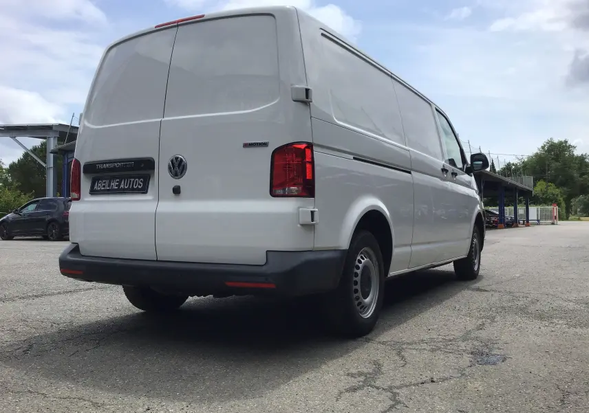 Vue 3/4 arrière droite d'un Volkswagen Transporter 6.1 blanc, fourgon utilitaire avec logo 4MOTION visible.