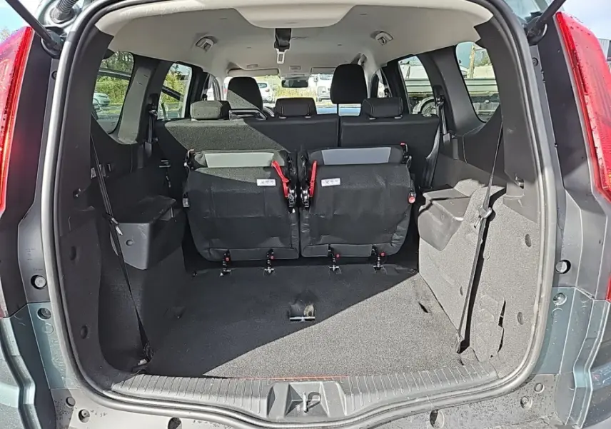 Vue arrière du coffre vert du Dacia Jogger Extreme Hybrid avec la troisième rangée de sièges rabattue en partie.