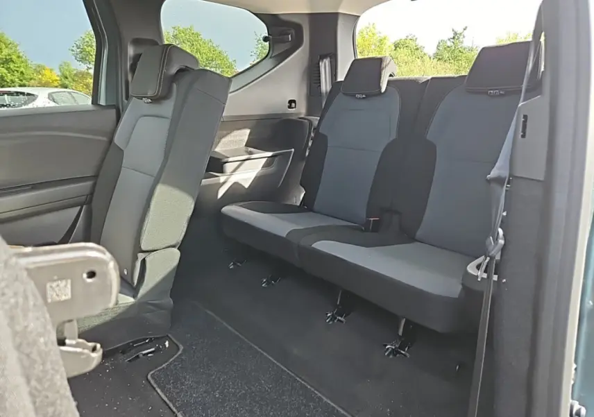 Vue intérieure de la 3ème rangée de sièges rabattables du Dacia Jogger hybride vert, côté droit ouvert.