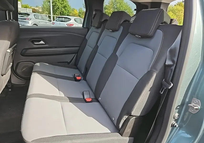 Banquette arrière 3 places en tissu gris et noir du Dacia Jogger vert, vue côté droit avec porte ouverte.