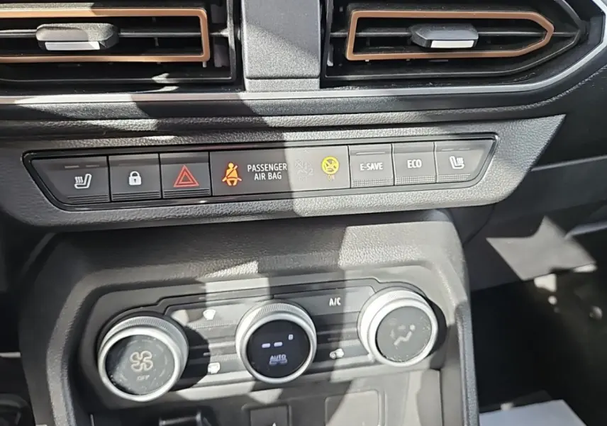 Vue rapprochée du tableau de bord central du Dacia Jogger 2024, montrant les commandes de climatisation et boutons fonctionnels.